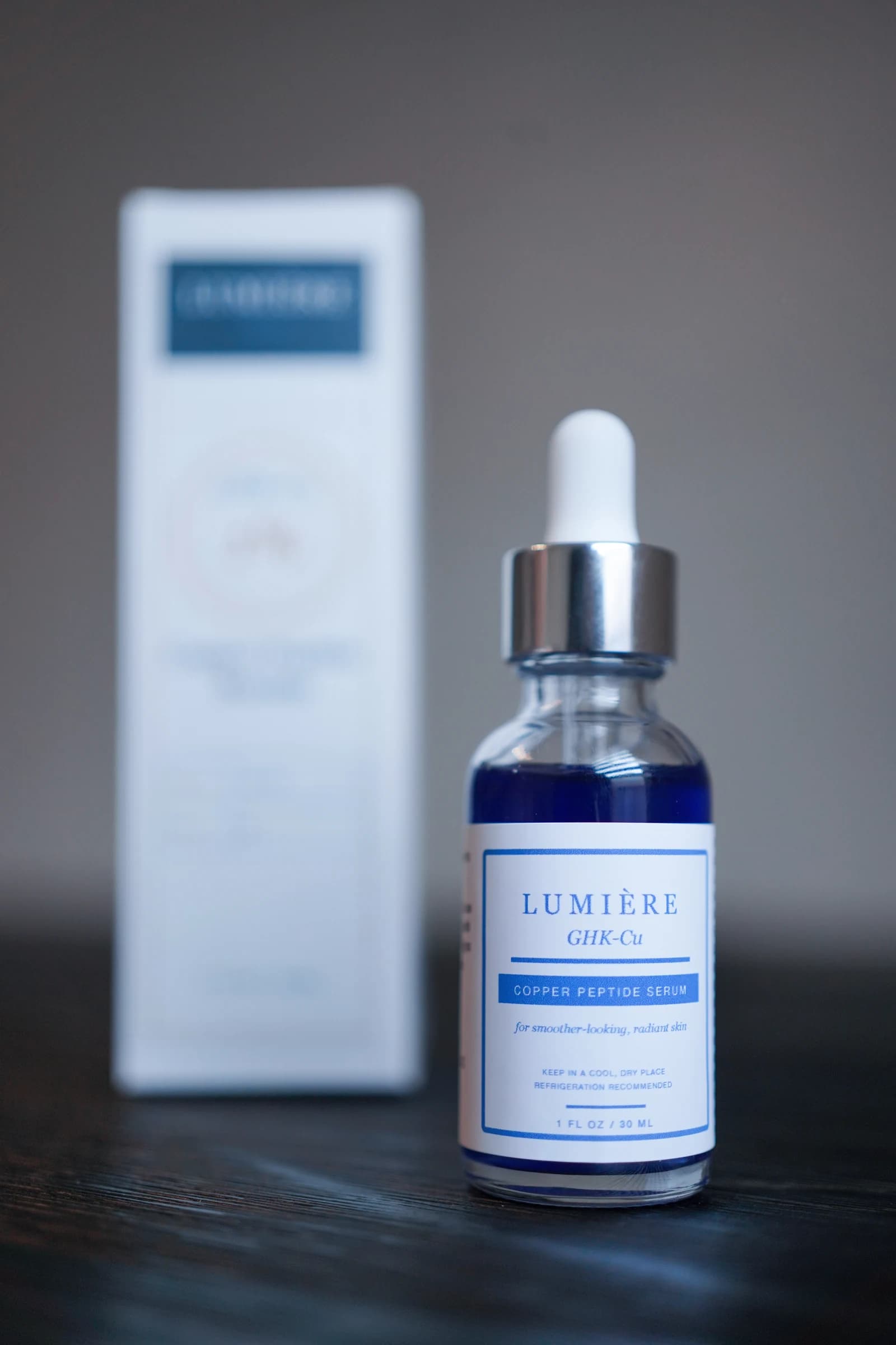 The complete Lumiere Routine GHK-Cu serum bottle beside its carton